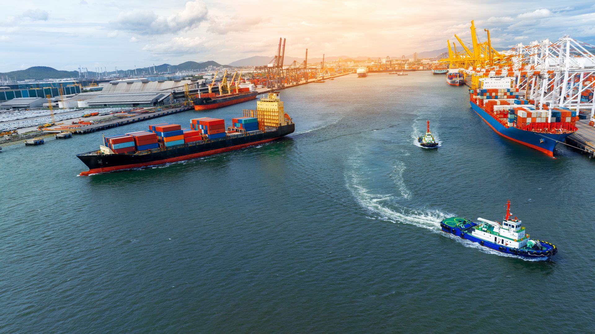 An aerial view of a cargo ship entering a harbor.