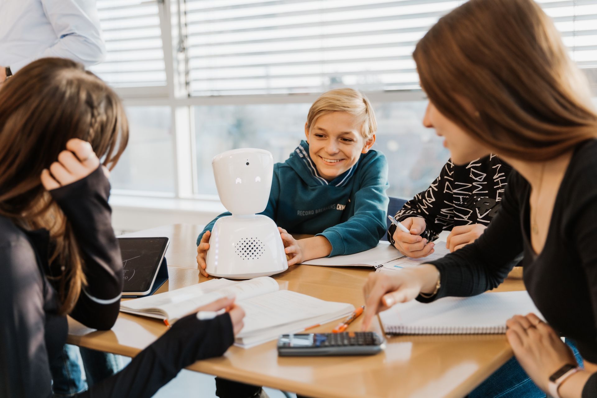 Un groupe de personnes sont assises autour d'une table avec un robot dessus
