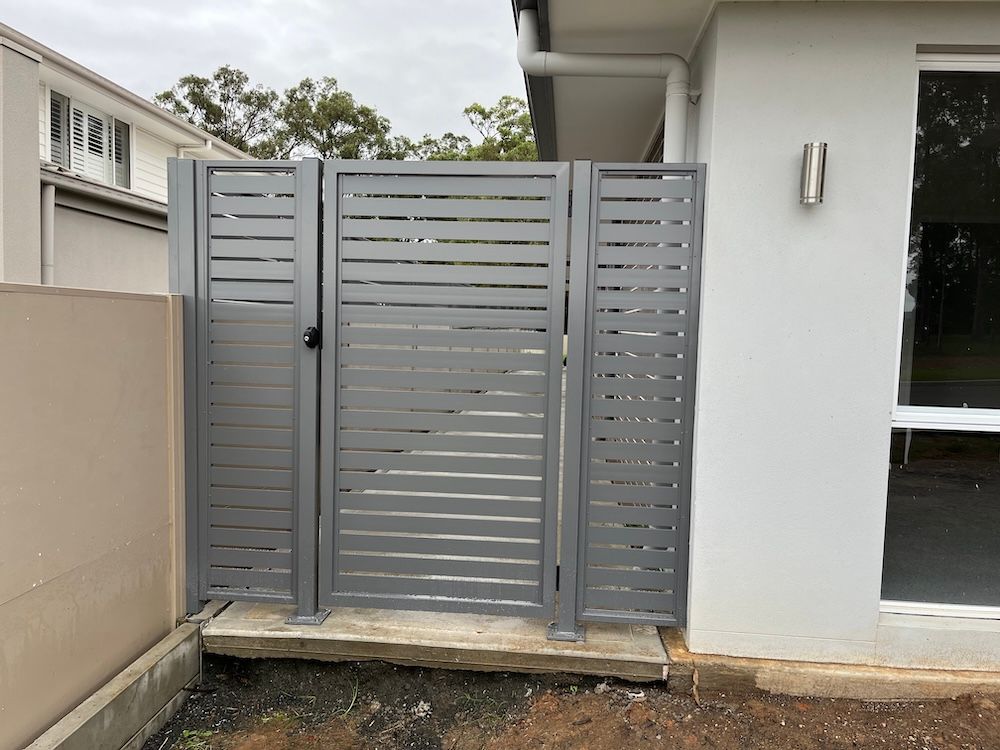 A Grey Fence on the Side of a House — Newcastle & MidCoast Privacy Screens & Gates In Kurri Kurri, NSW