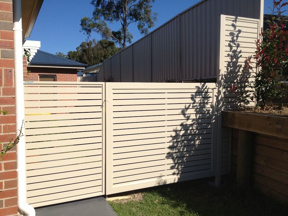 A Beige Fence on the Side of a House — Newcastle & MidCoast Privacy Screens & Gates In Mid North Coast, NSW