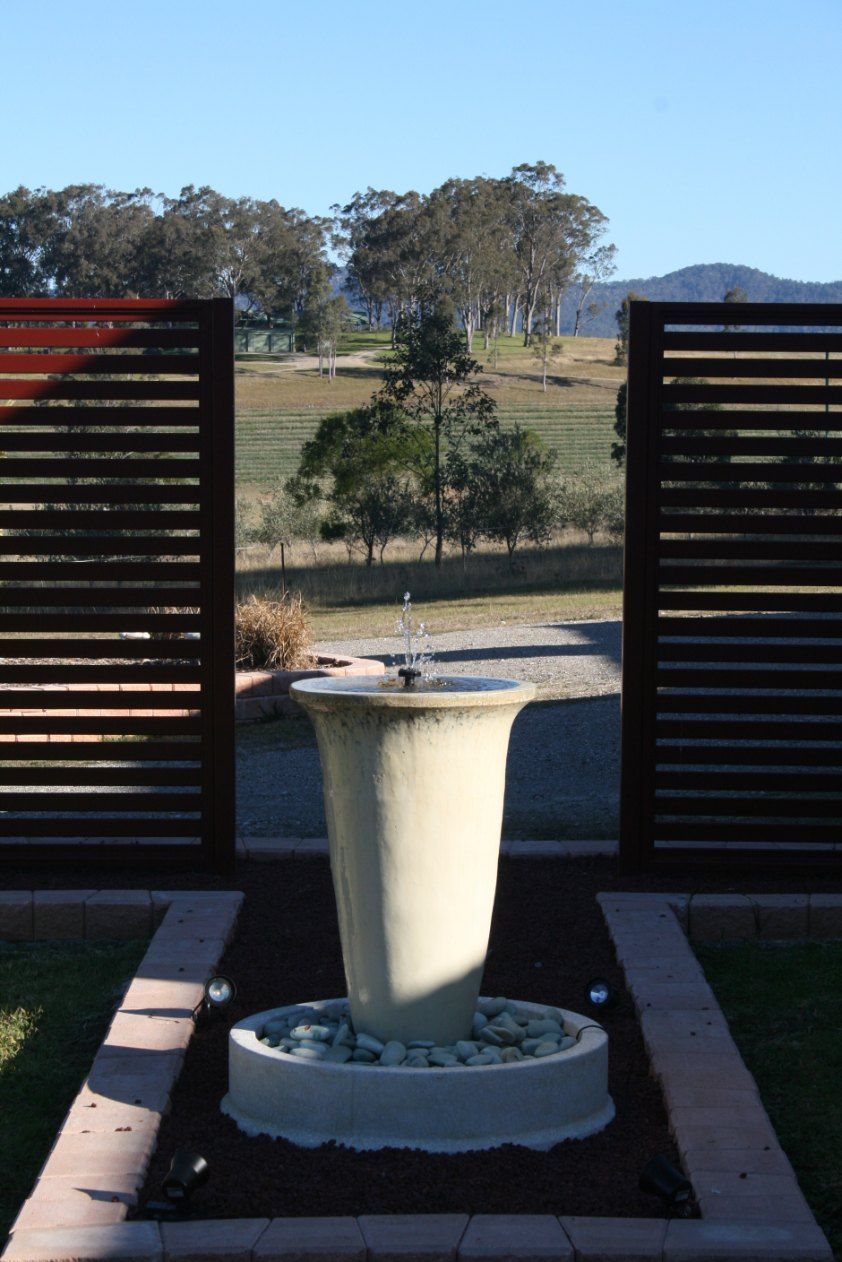 A Fountain in a Garden With a Fence in the Background — Newcastle & MidCoast Privacy Screens & Gates In Kurri Kurri, NSW