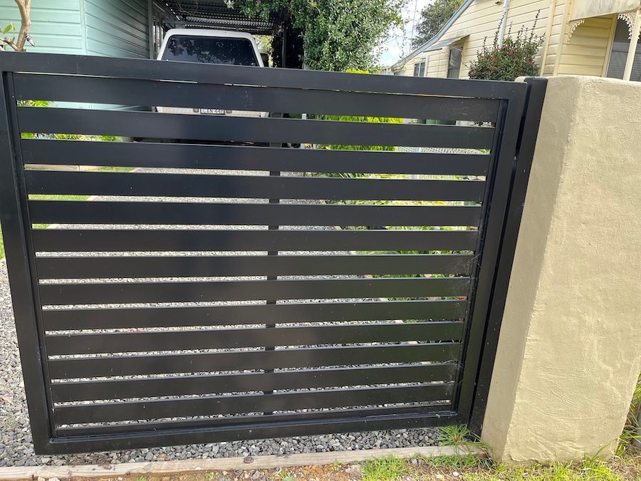 A Black Metal Fence in Front of Car — Newcastle & MidCoast Privacy Screens and Gates In Kurri Kurri, NSW