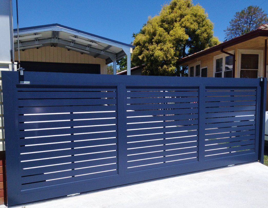 A Blue Sliding Gate is in Front of a House — Newcastle & MidCoast Privacy Screens and Gates In Kurri Kurri, NSW
