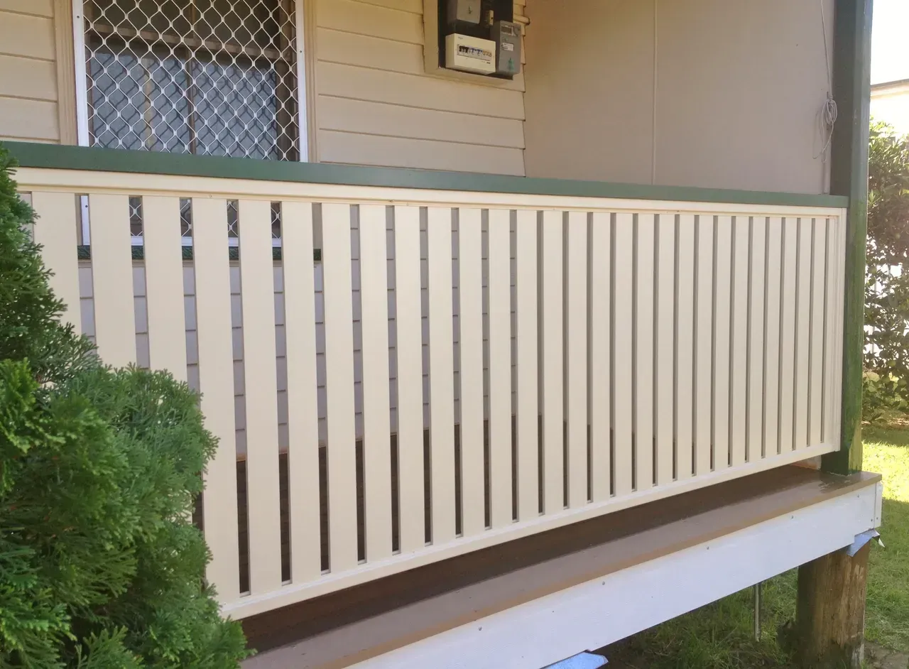 A White Fence Is Sitting On The Side Of A House — Newcastle & MidCoast Privacy Screens and Gates In Kurri Kurri, NSW