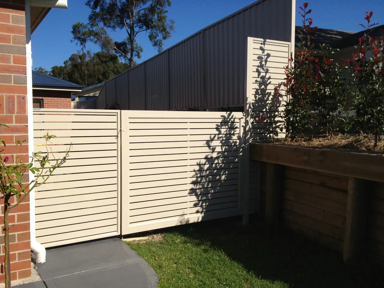 A White Fence is in the Backyard of a House — Newcastle & MidCoast Privacy Screens & Gates In Kurri Kurri, NSW
