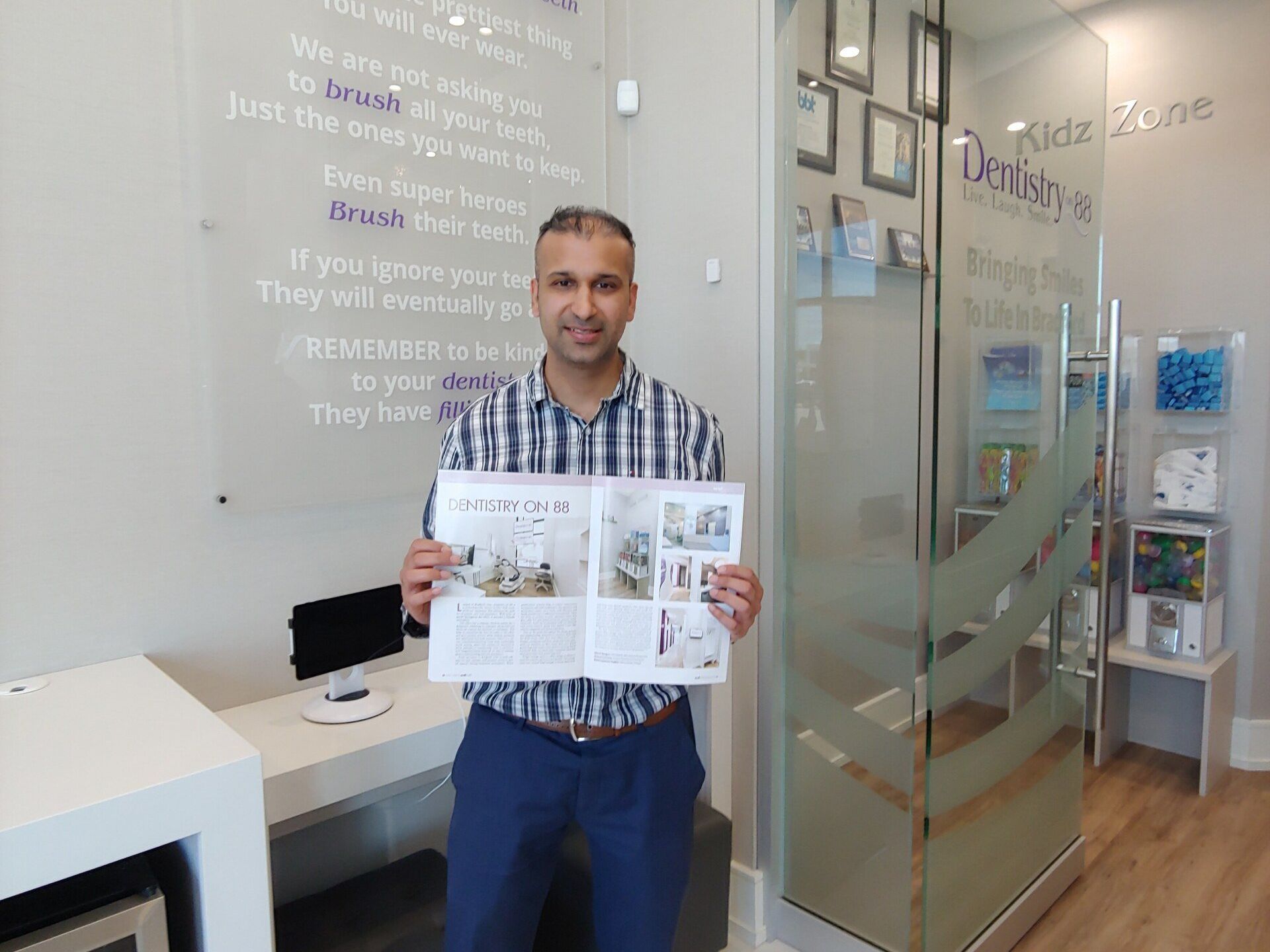 Man in striped shirt holding an open brochure inside a bright office reception area