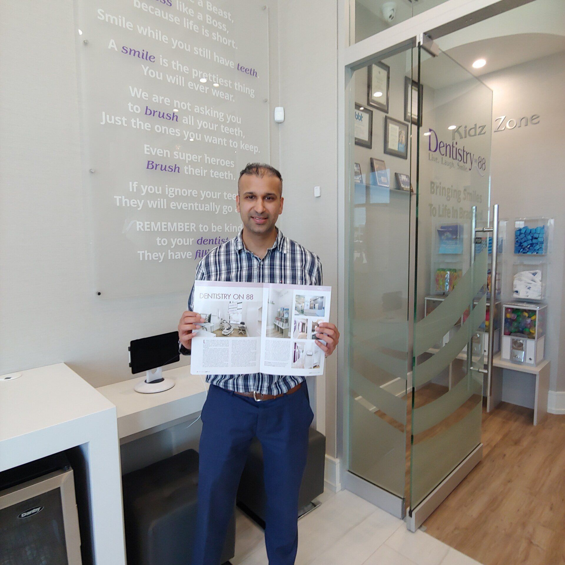 Man holding an open brochure in a modern office lobby with glass doors and wall text
