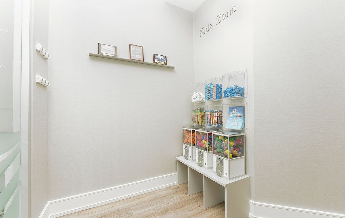 Small bright pantry with shelves of boxed and canned food along a white wall.
