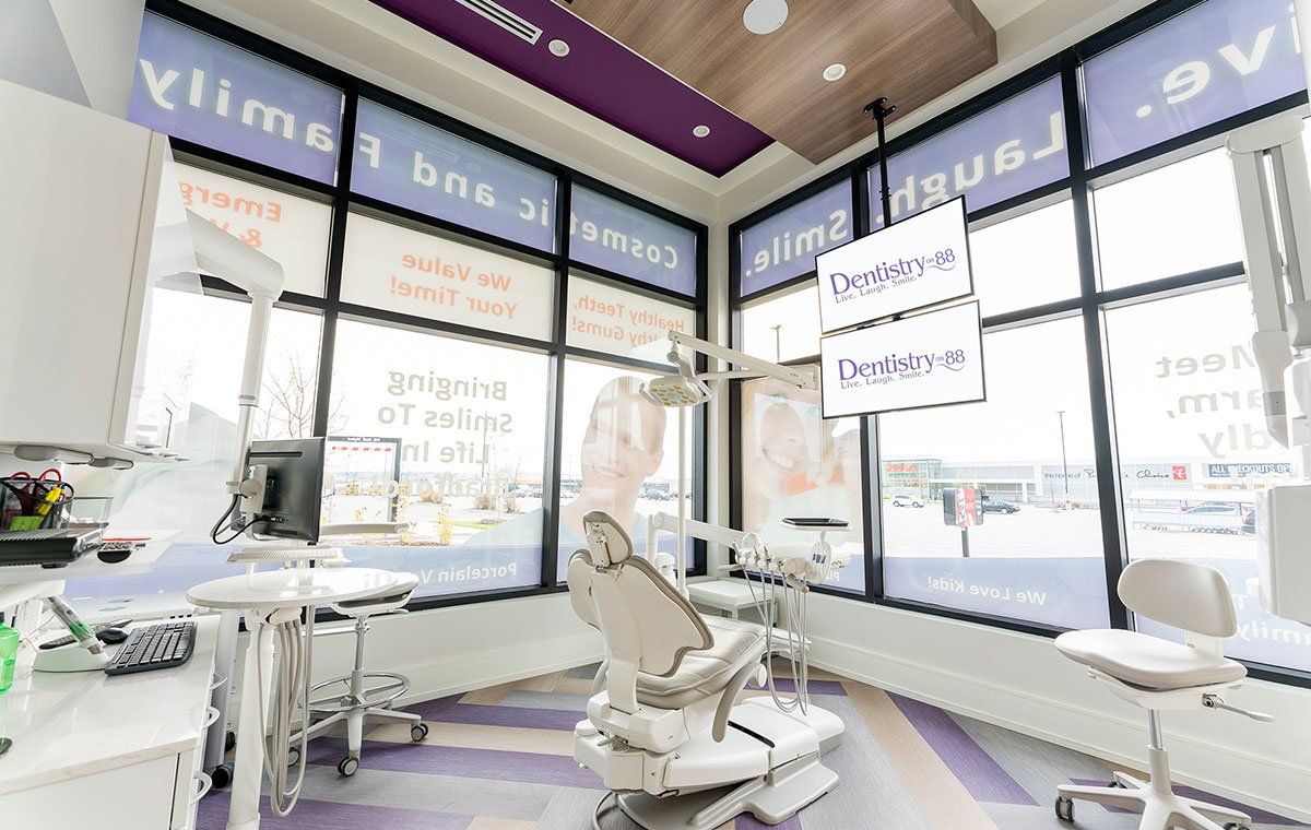 Bright modern dental clinic with chairs, equipment, and large windows.