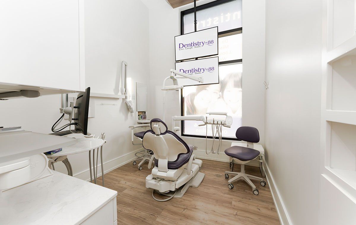 Bright dental exam room with chair, dentist tools, and monitor by a window
