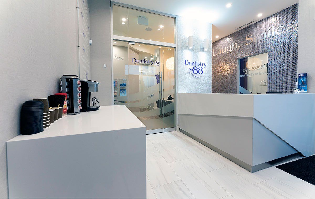 Modern lobby with white desks, glass doors, and blue mosaic wall panels
