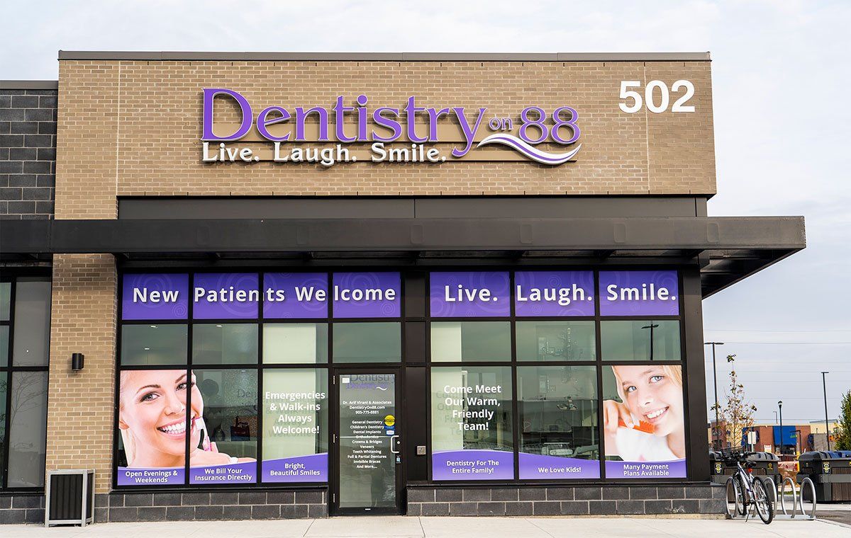 Dentistry 33 storefront with purple signage and window posters in a strip mall.