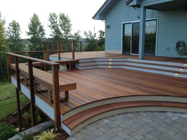A blue house with a wooden deck in front of it