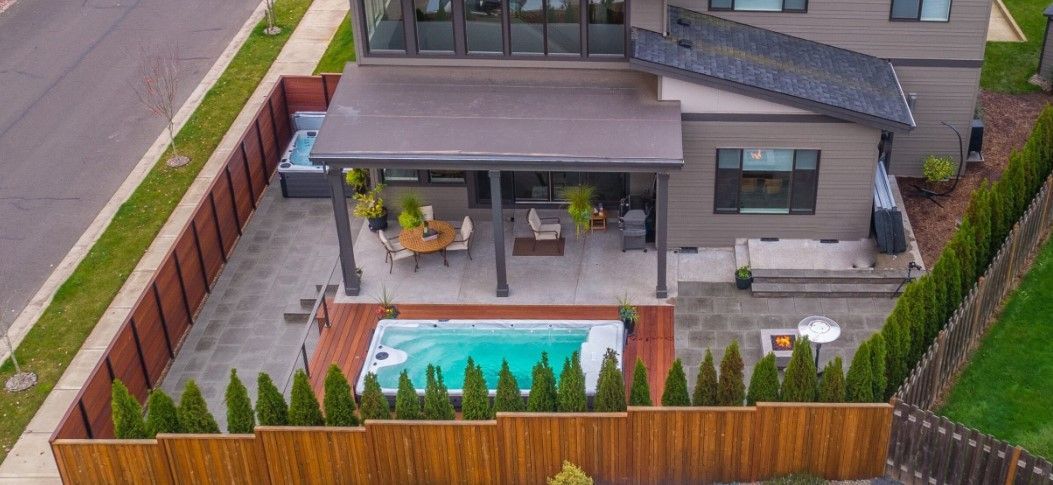 An aerial view of a house with a large swimming pool in the backyard.