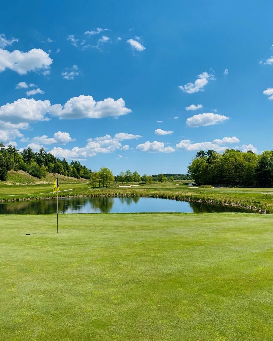 A golf course with a pond in the middle of it