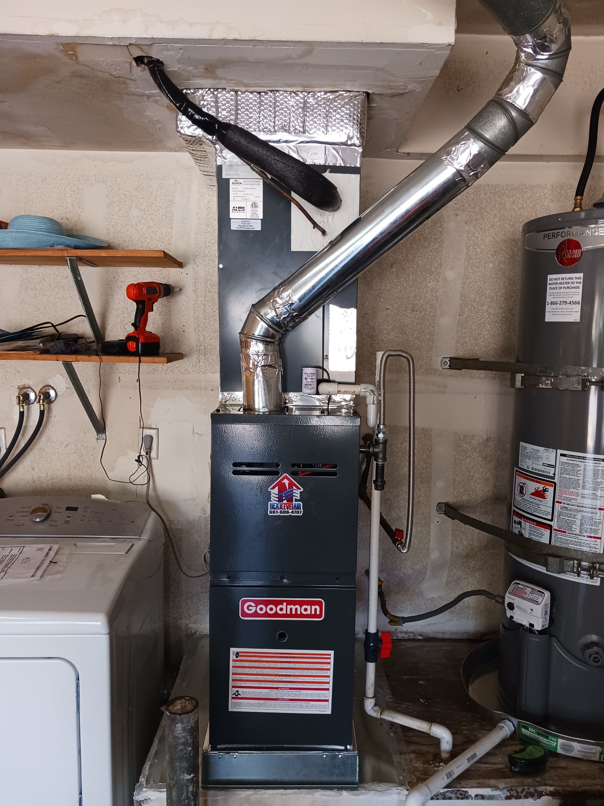Basement utility area with a blue furnace, water heater, and metal vent pipes.