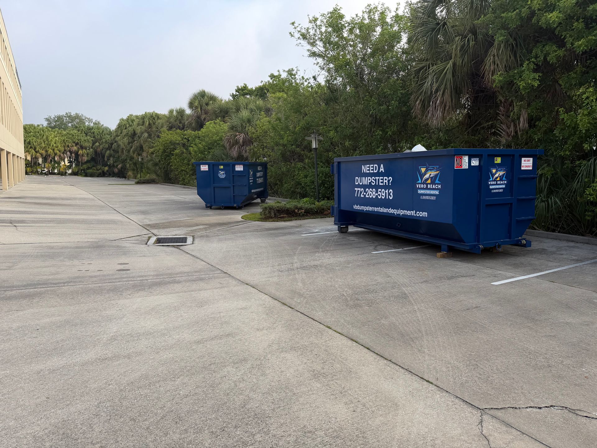 Blue dumpster on a sunny day.