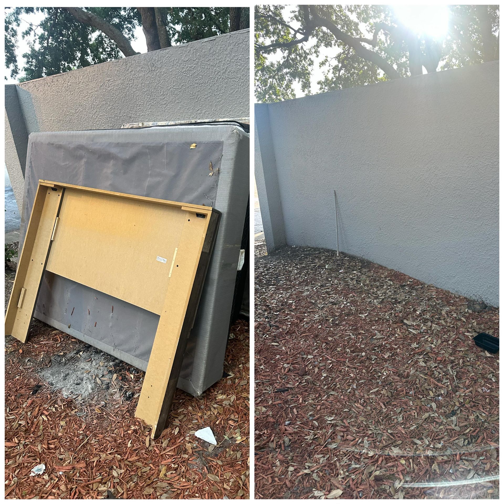 Leaning wooden board against a gray outdoor wall with mulch and trees nearby