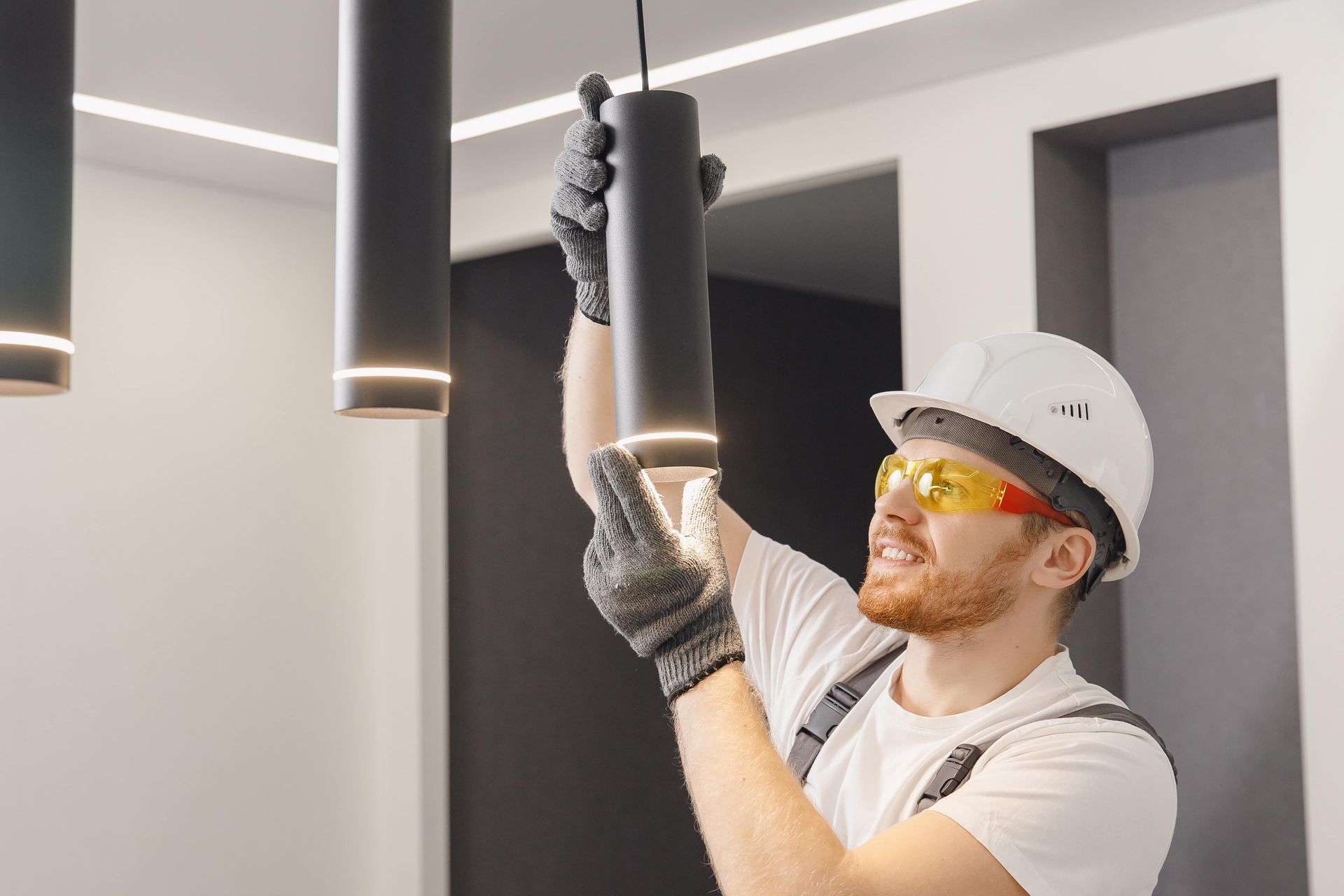 A man is installing a light fixture in a room.
