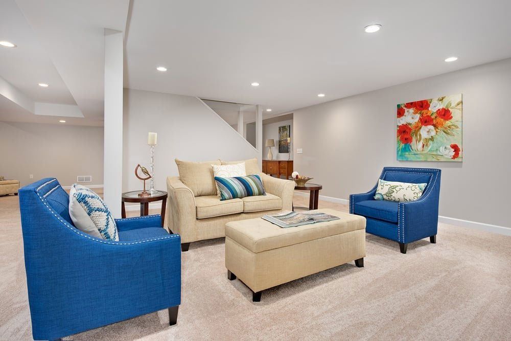 A living room with a couch, chairs, and ottoman.