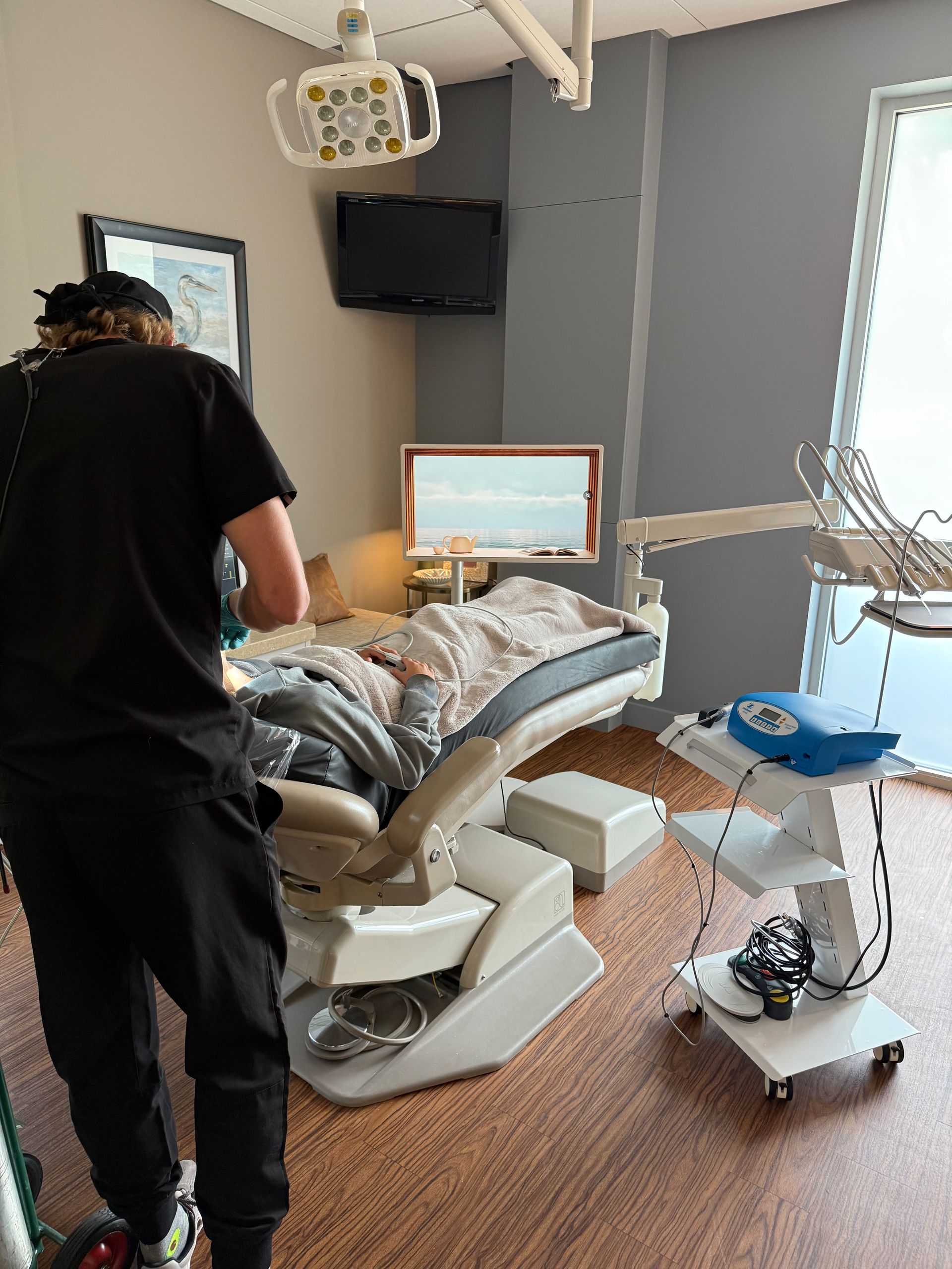 Doctor in scrubs working with sedated patient