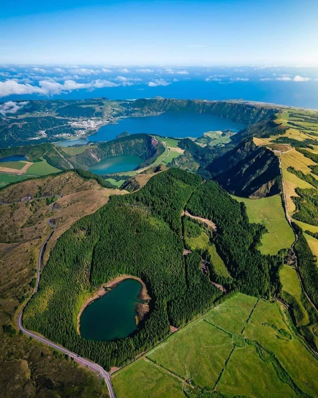 Aerial view of Sete Cidades in the Azores, featuring lush volcanic craters filled with lakes and vibrant green landscapes.