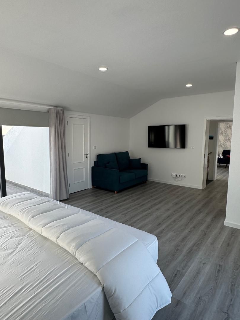 A bedroom with a bed , couch and television.