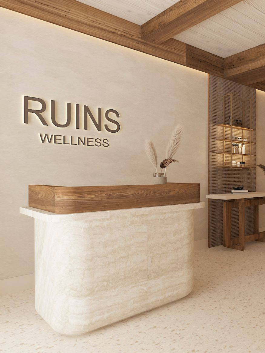 A modern, minimalist reception desk with a cream stone base and dark wood counter, featuring 