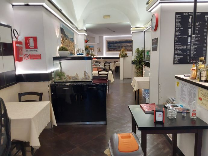Un ristorante con tavoli e sedie e un estintore sul muro