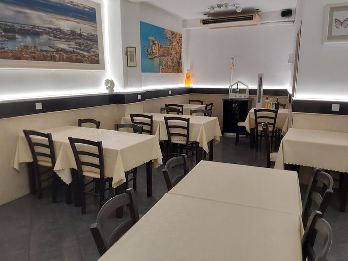 Un ristorante con tavoli e sedie e un dipinto sul muro