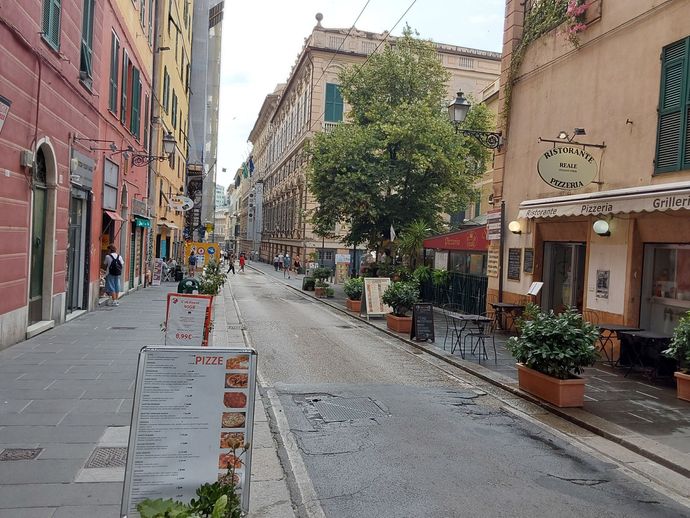 Una strada stretta con un cartello che dice 