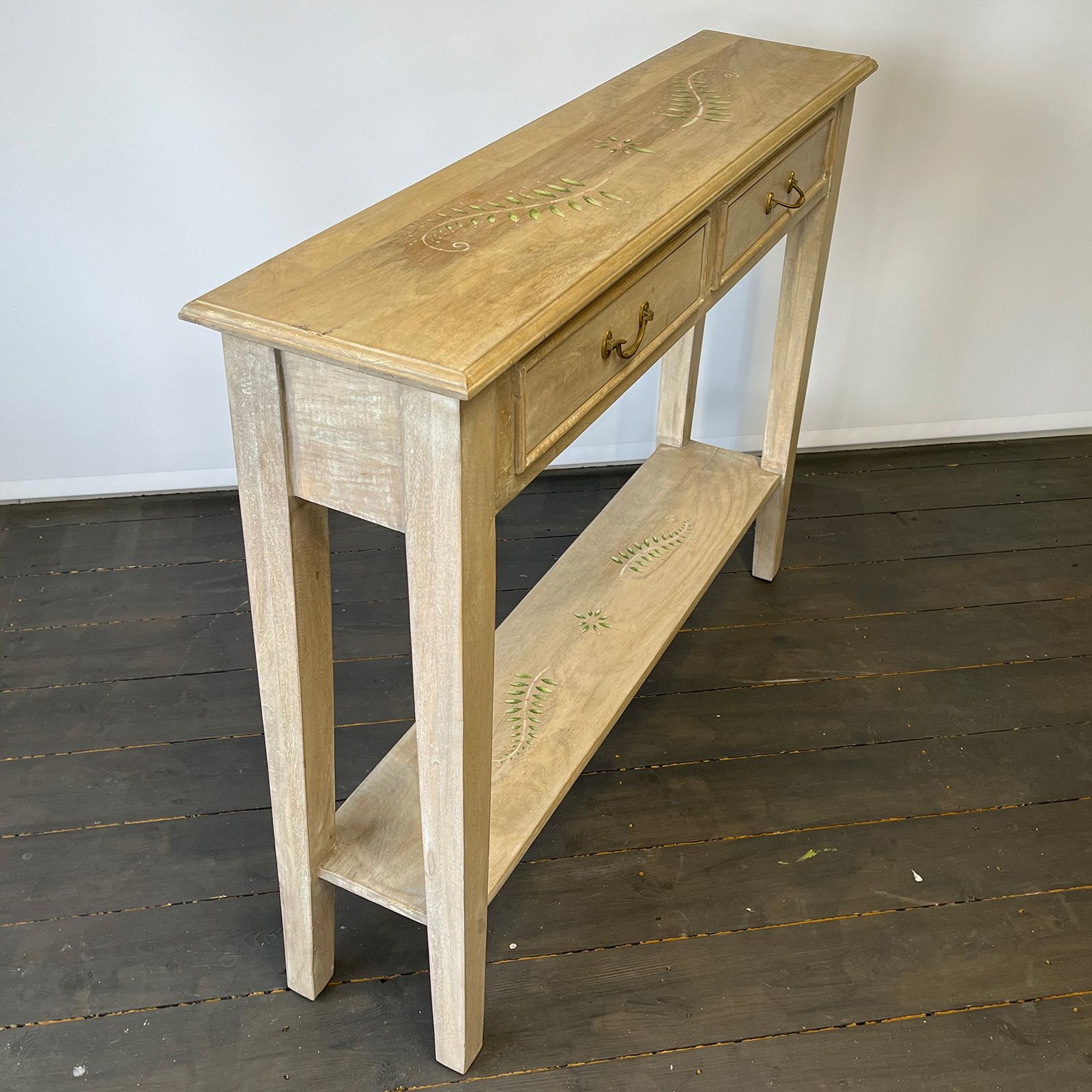Console table with decorative design om top and base shelf.