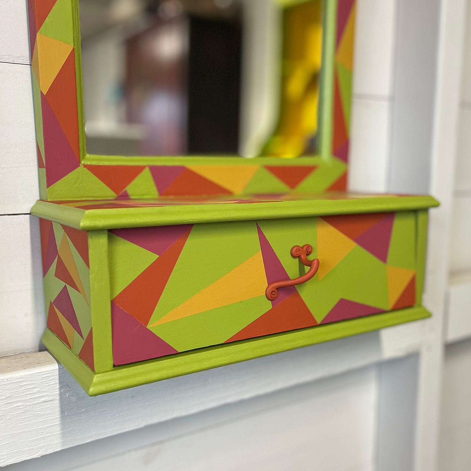 A wall mirror drawer upcycled with paint in carnival colours