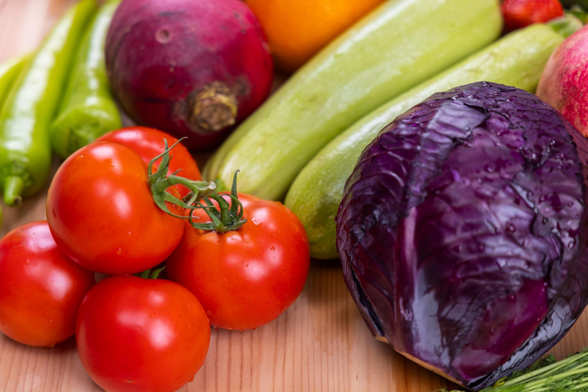 Primer plano de verduras frescas y coloridas: tomates, repollo, calabacines, pimientos y remolachas.