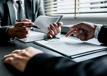 People at a desk looking at documents together.