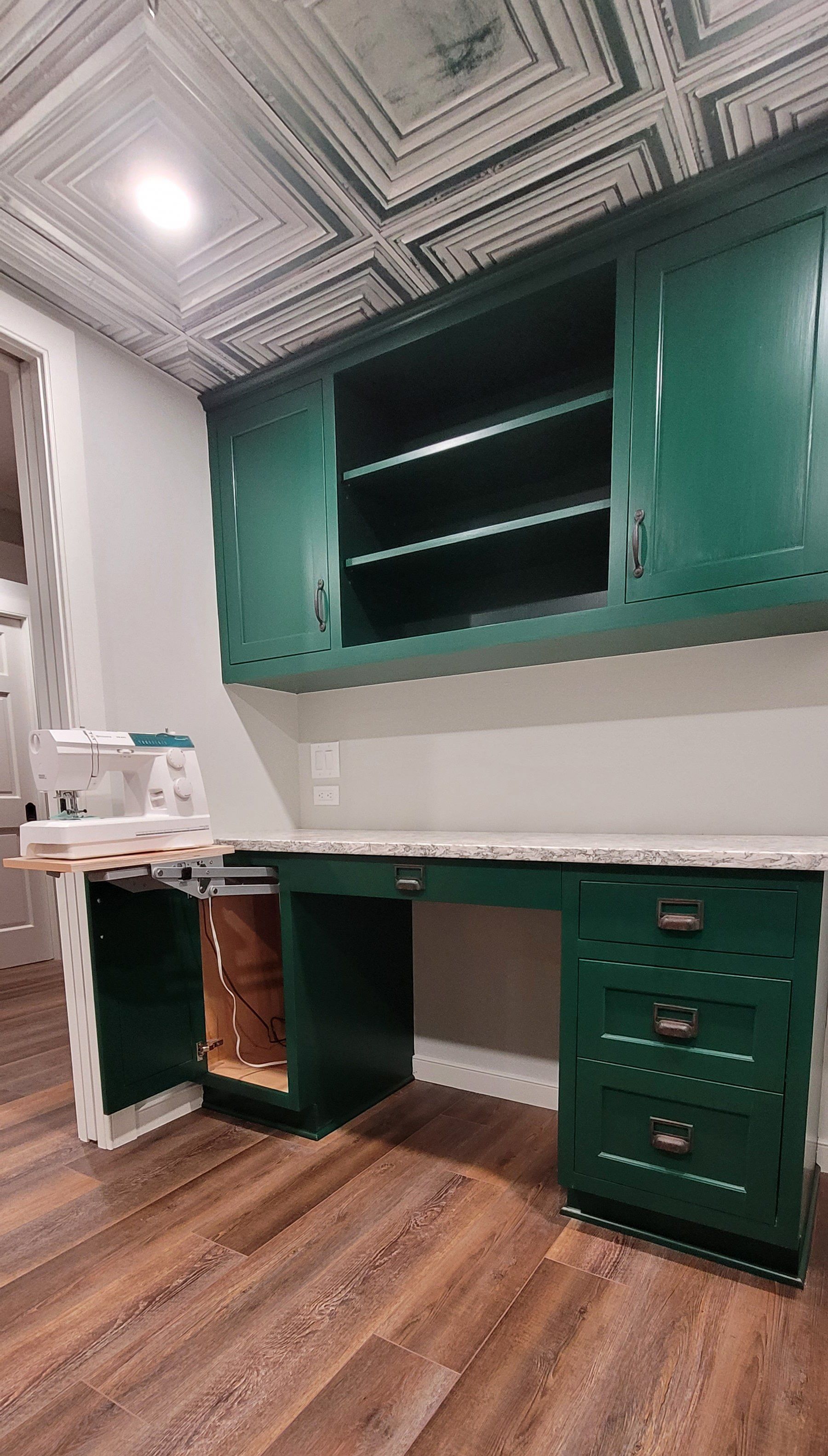 A kitchen with green cabinets and a white counter top.