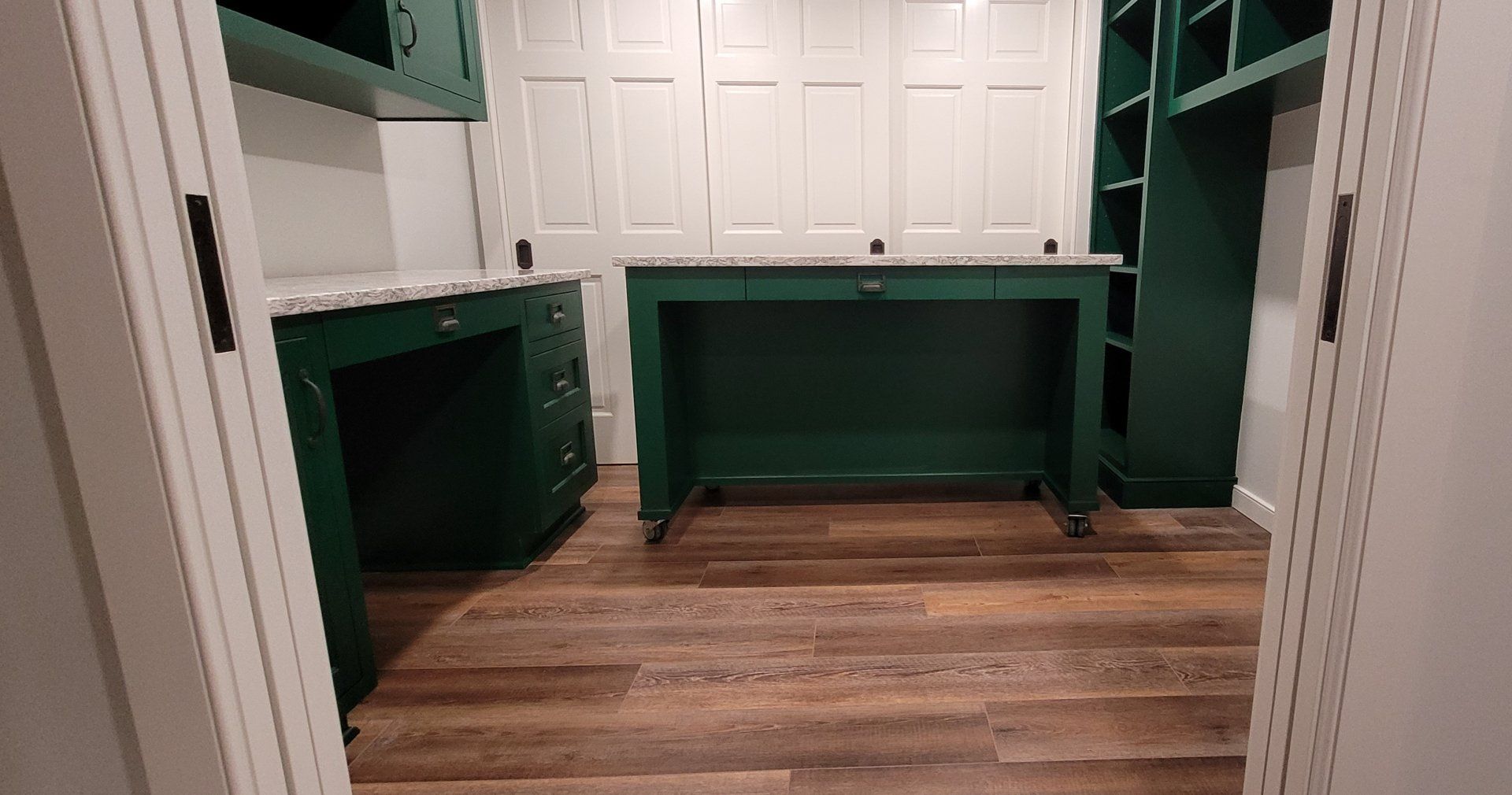 There is a green desk in the middle of the room.