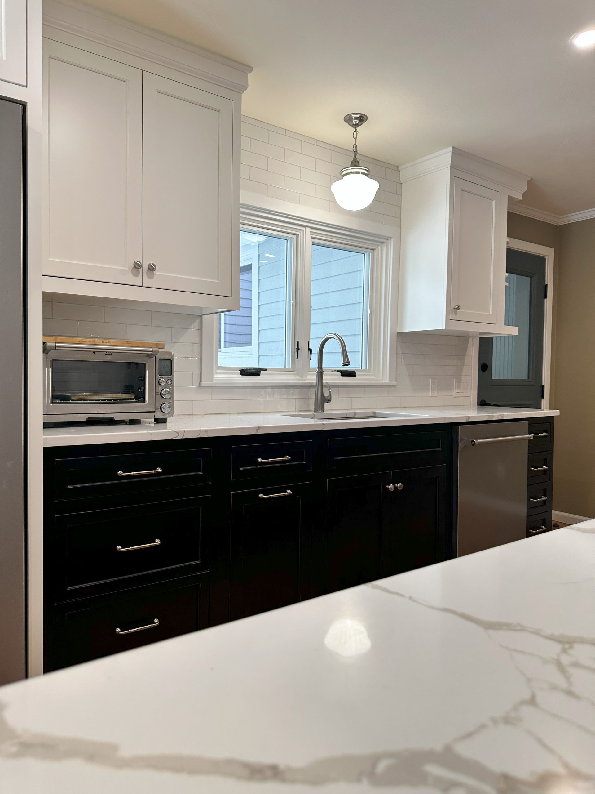 A kitchen with black cabinets and white counter tops