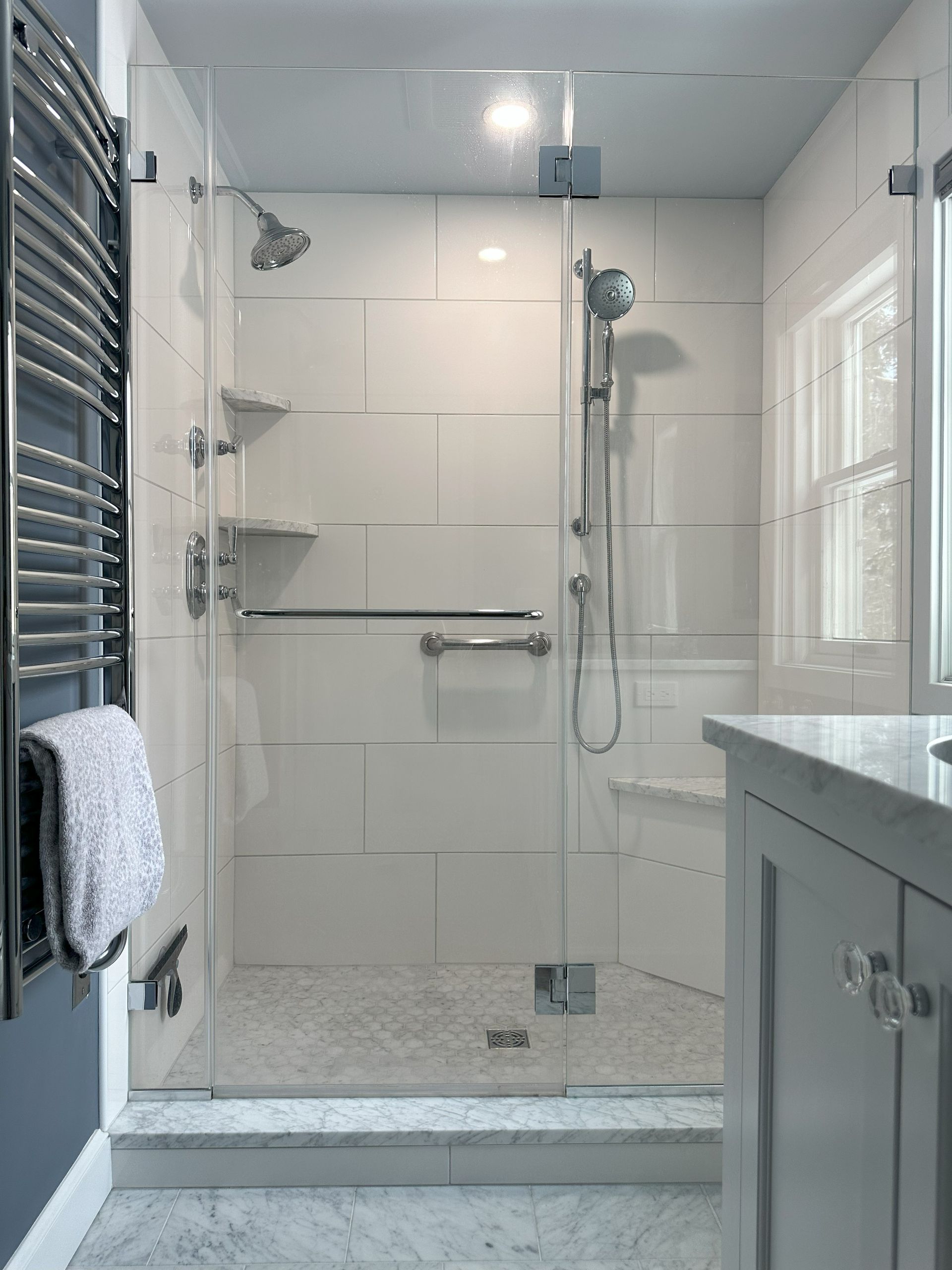 A bathroom with a walk in shower and a sink.
