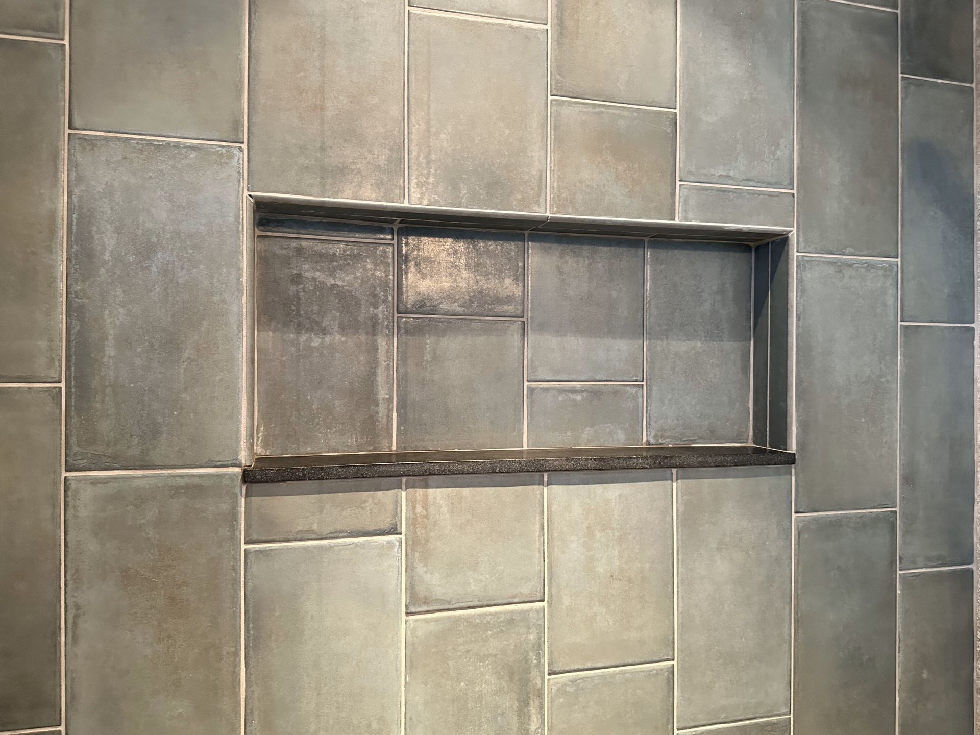 A tiled wall with a niche in the middle