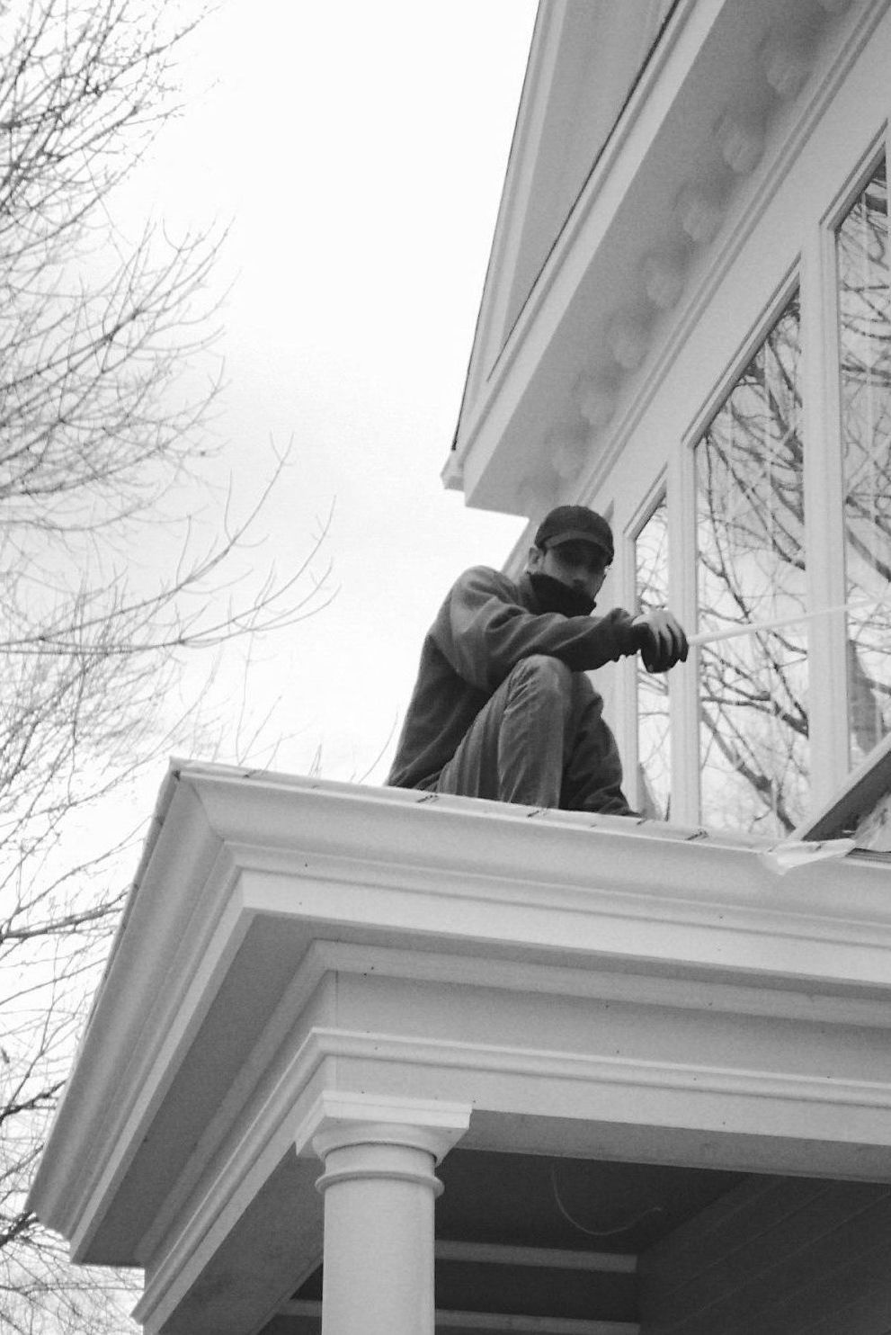 A man is kneeling on the porch of a house