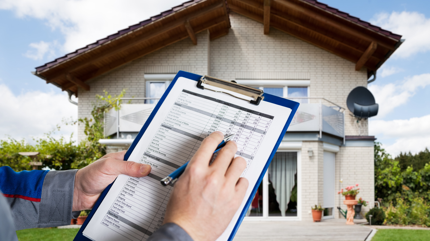 Hand writing on a clipboard in front of a house with a solar panel on the roof.