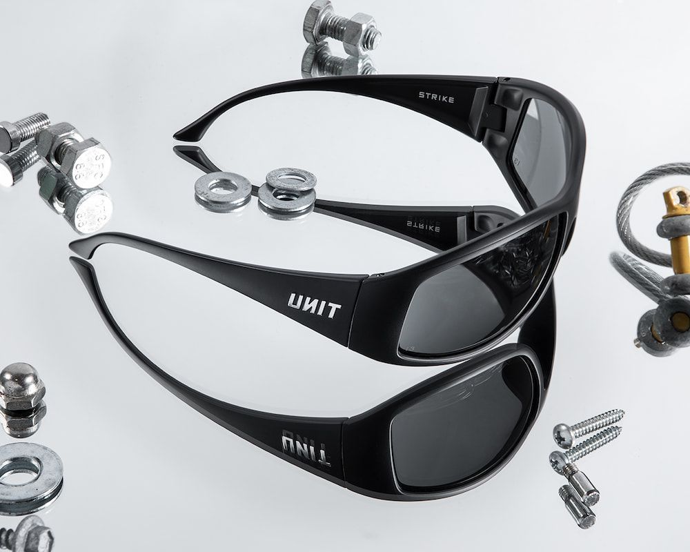 Black Unit Sunglasses on a Reflective Surface — Workwise Clothing Forster in Forster, NSW