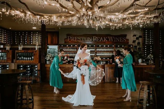 A bride and her bridesmaids are posing for a picture in a wine store.