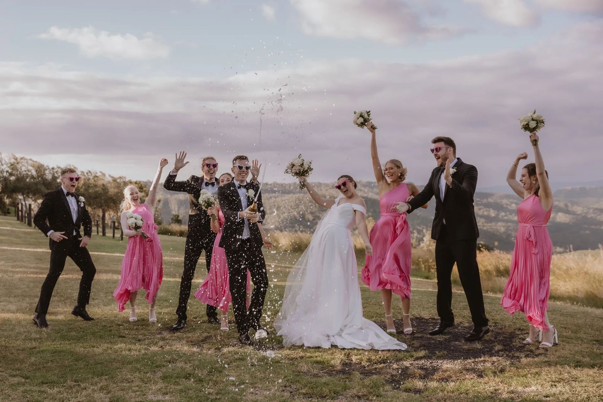 A bride and groom are posing for a picture with their wedding party.