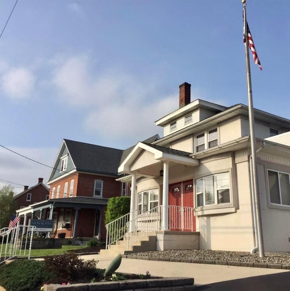 Buildings, including one with an American flag, on a sunny day.