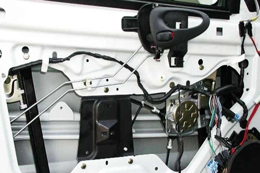 Window repair showing the inside of a white car with a lot of wires coming out 