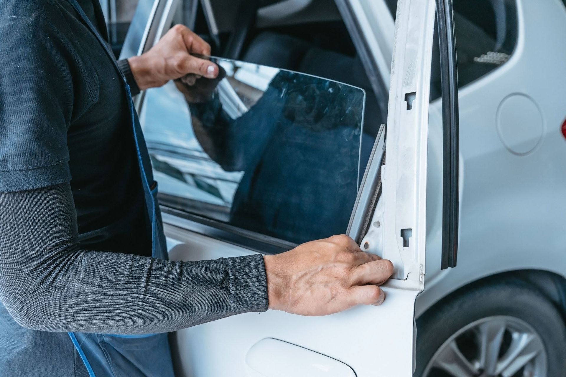 A man is installing a window tint on a car door.