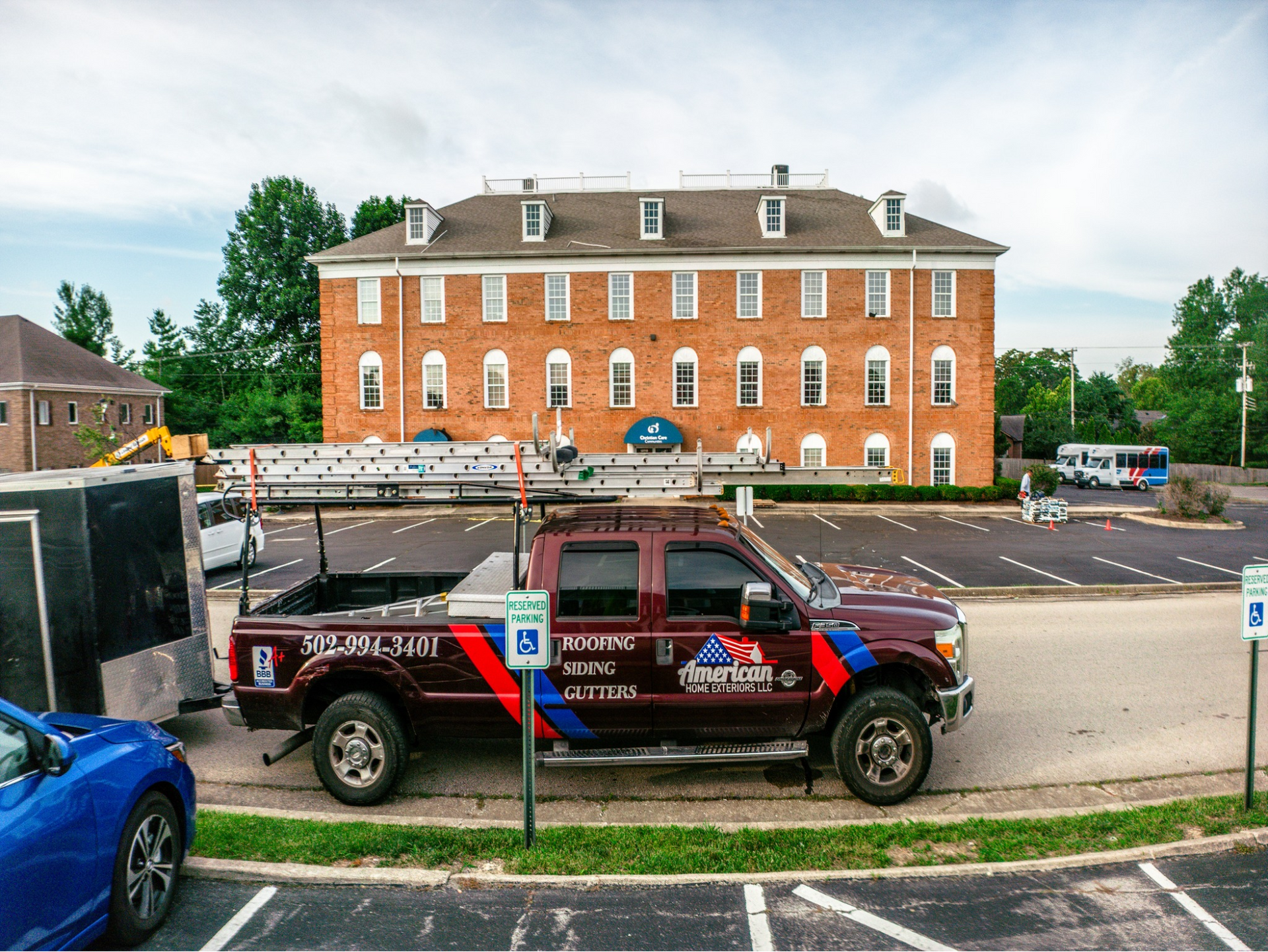 A truck is parked in a parking lot in front of a large brick building.