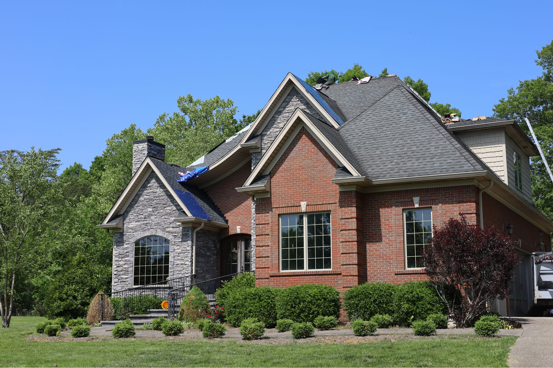 a brick house with a roof that is being installed